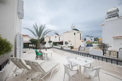 a patio with chairs and tables on a balcony at Peaceful Cozy Home Great Location in Protaras