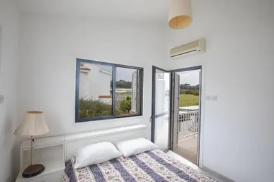 a bedroom with a bed and two windows at Peaceful Cozy Home Great Location in Protaras