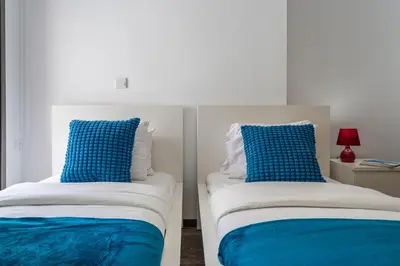 two beds with blue and white pillows in a room at Crystal 2-Bedroom Apartment in Larnaca in Larnaka