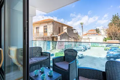 a balcony with chairs and a view of a parking lot at Crystal 2-Bedroom Apartment in Larnaca in Larnaka