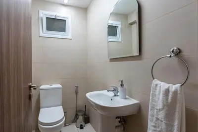 a bathroom with a sink and a toilet and a mirror at Celeste 3-Bedroom Apartment in Larnaca in Larnaka