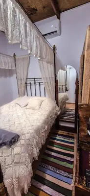 a bedroom with a canopy bed with curtains and a rug at Angels Traditional House in Arminou