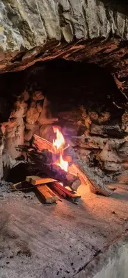 a fireplace with a fire in a cave at Angels Traditional House in Arminou