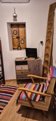 a room with a bed and a desk with a laptop at Angels Traditional House in Arminou