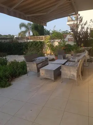 a patio with a table and chairs under a roof at LULA VILLA in Ayia Napa