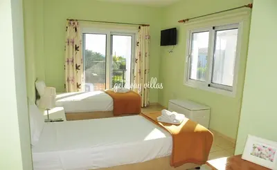 a bedroom with two beds and a window at LULA VILLA in Ayia Napa