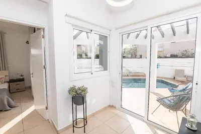 a living room with a sliding glass door leading to a pool at Lindos Villa Ekaterina in Paralimni