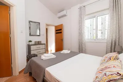 a white bedroom with a bed and a window at Lindos Villa Ekaterina in Paralimni
