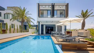 a villa with a swimming pool and a house at Sunrise Beachfront Villas - Villa 1 in Paralimni