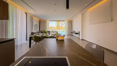 a living room with a table and a dining room at Sunrise Beachfront Villas - Villa 1 in Paralimni