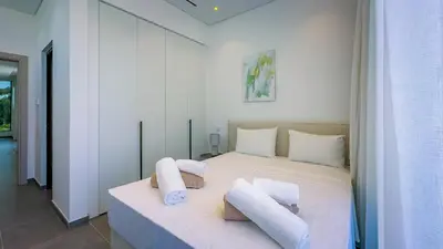 a bedroom with a white bed with pillows on it at Sunrise Beachfront Villas - Villa 1 in Paralimni