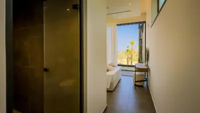 a bathroom with a shower and a window with a toilet at Sunrise Beachfront Villas - Villa 1 in Paralimni