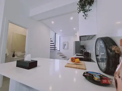 a white kitchen with a large clock on a counter at STAY Anemone 19 in Protaras