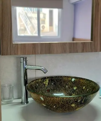 a bathroom sink with a stone bowl sink at Palm Sea Suite 17 in Larnaka