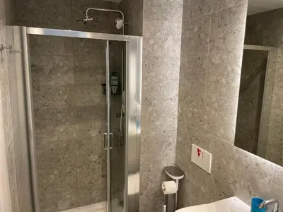 a shower with a glass door in a bathroom at Gaia Seaview Apartment 1 in Larnaka