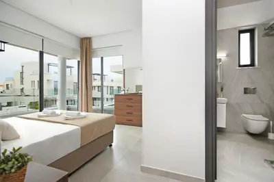 a bedroom with a large bed and a bathroom at Villa Queen Alexandra in Protaras