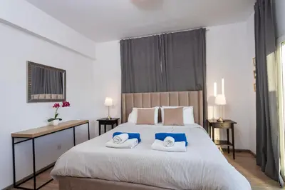 a bedroom with a large bed with two towels at Palm Beach Apartment by TrulyCyprus in Limassol