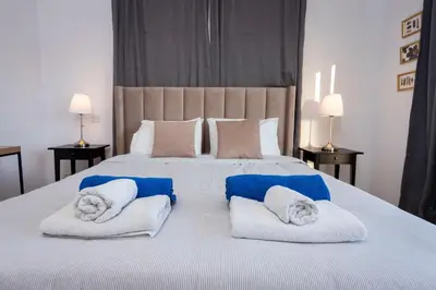 a bedroom with a large bed with towels on it at Palm Beach Apartment by TrulyCyprus in Limassol