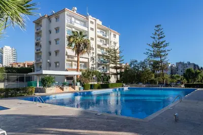 a large swimming pool in front of a building at Palm Beach Apartment by TrulyCyprus in Limassol