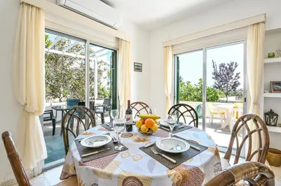 a dining room with a table and chairs and a window at Villa 361-Walk to Protaras Fig Tree Bay & Amenities in Protaras