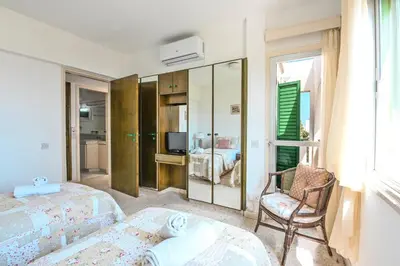 a hotel room with two beds and a chair at Villa 361-Walk to Protaras Fig Tree Bay & Amenities in Protaras