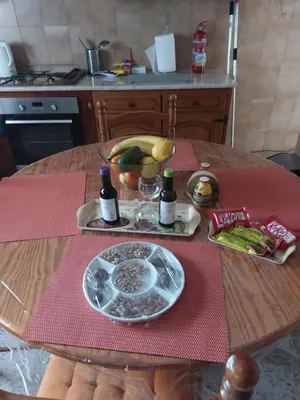 a table with a plate of food and bottles of wine at Kyri's Place Larnaca in Larnaka