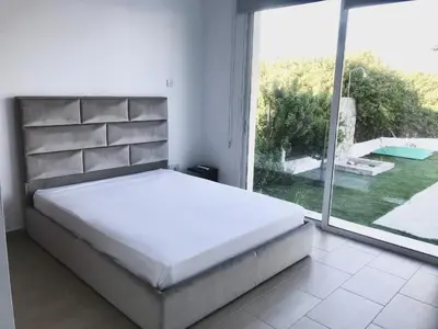 a bedroom with a large bed and a large window at Villa Poseidon in Pervolia