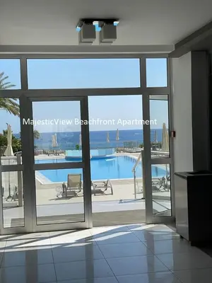 a view of a swimming pool through a glass door at MagesticView seafront apartment in Protaras