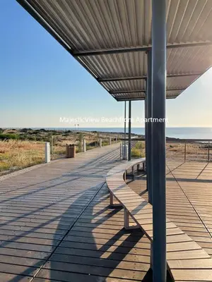 a row of benches on a boardwalk near the beach at MagesticView seafront apartment in Protaras