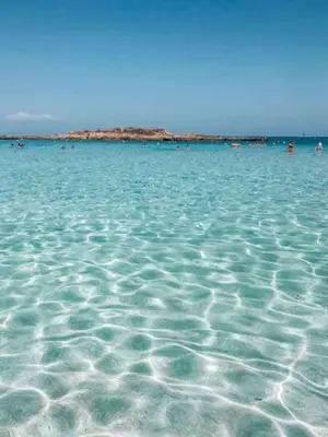 a large body of water with people swimming in it at MagesticView seafront apartment in Protaras