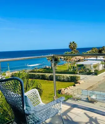a bench sitting on a patio overlooking the ocean at MagesticView seafront apartment in Protaras