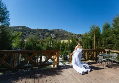 a woman in a white dress sitting on a deck at Amazing Cyprus Glamping Domes - Glamping Cyprus in Paphos City