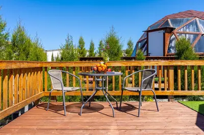 a table and chairs on a deck with a gazebo at Amazing Cyprus Glamping Domes - Glamping Cyprus in Paphos City