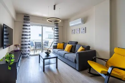 a living room with a couch and a table at Vox 2-Bedroom Apartment in Larnaca in Larnaka