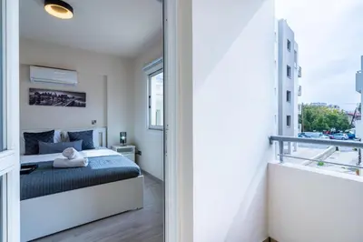 a bedroom with a bed and a balcony at Vox 2-Bedroom Apartment in Larnaca in Larnaka