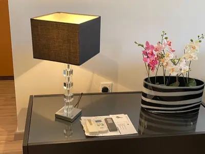 a table with a lamp and a vase of flowers at Belleview Heights in Limassol