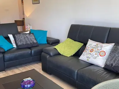 a living room with a black leather couch with colorful pillows at Belleview Heights in Limassol