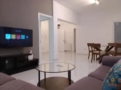 a living room with a table and a tv at Zelea Deluxe Apartment (BREAKBOOKING CY) in Limassol