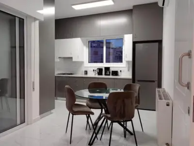 a kitchen with a table and chairs and a refrigerator at Zelea Deluxe Apartment (BREAKBOOKING CY) in Limassol