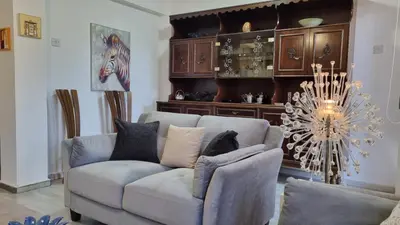 a living room with a couch and a chandelier at Elpida Lemon Garden House in Limassol