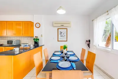 a kitchen with a table with blue plates on it at Villa Sunnyside Mandali by Ezoria Villas in Protaras