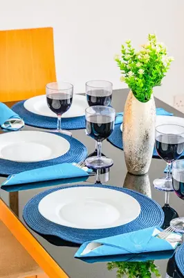 a table with blue and white plates and wine glasses at Villa Sunnyside Mandali by Ezoria Villas in Protaras