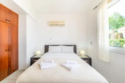 a bedroom with a bed with two towels on it at Villa Sunnyside Mandali by Ezoria Villas in Protaras