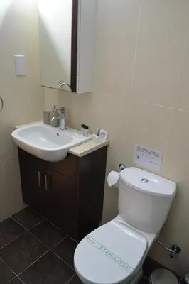 a bathroom with a white toilet and a sink at Pebble in Protaras