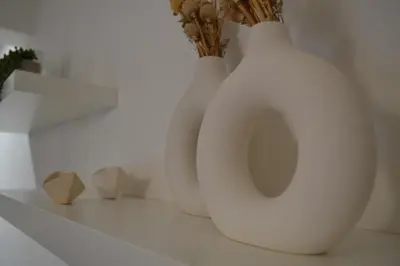 two white vases are sitting on a shelf at Pebble in Protaras