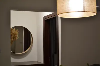a mirror on a wall next to a lamp at Pebble in Protaras
