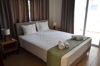 a bedroom with a bed with two towels on it at Pebble in Protaras