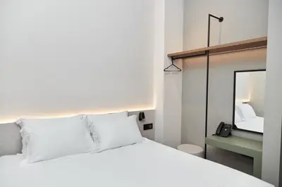a bedroom with a white bed and a mirror at Alinea Primo Historic Center in Limassol