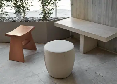 a bench and a stool sitting next to a table at Alinea Primo Historic Center in Limassol