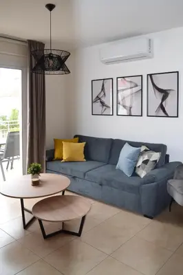 a living room with a blue couch and a table at Sweet Retreat in Paralimni